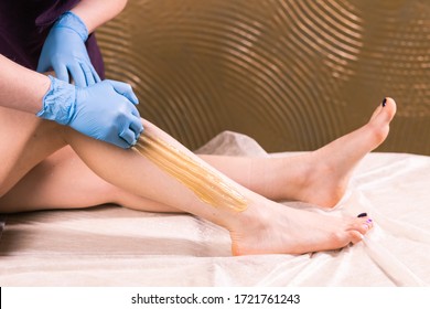 Sugaring epilation skin care with liquid sugar at legs. You can see her smooth and hair free legs after hair removal close-up. Beauty and cosmetology concept.