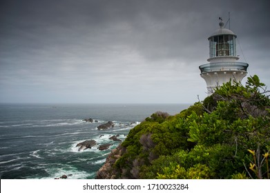 Sugarloaf Point Lighthouse At Seal Rocks, Myall Lakes National Park, NSW, Australia. Lighthouse On Hilltop, Rough Seas And Grey Cloud Sky