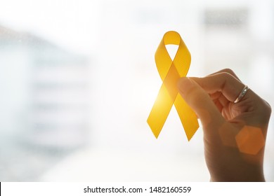 Suicide Prevention And Childhood Cancer Awareness, Yellow Ribbon For Supporting People Living And Illness. Children Healthcare And World Cancer Day Concept