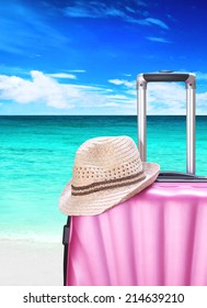 suitcase and hat on the beach
