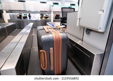 Suitcase On Luggage Conveyor Belt System At Check In Desk In Airport