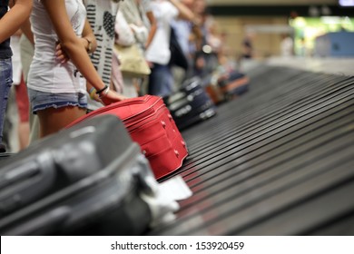 Suitcase on luggage conveyor belt in the baggage claim at airport - Shutterstock ID 153920459