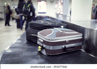 Suitcase On Luggage Conveyor Belt In The Baggage Claim At Airport