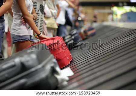 Suitcase on luggage conveyor belt in the baggage claim at airport