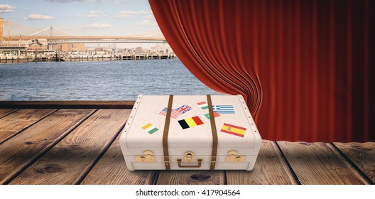 Suitcase With Stickers Against Red Curtain Pulling Back