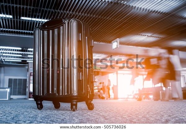 Suitcases in airport departure gates in the\
airport international over blurred tourists traveling around the\
world. airport terminal waiting area  interior with large windows,\
focus on suitcases.