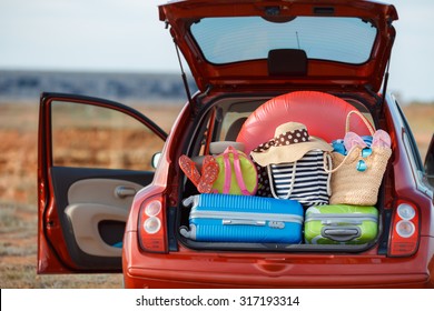 Suitcases and bags in trunk of car ready to depart for holidays. Moving boxes and suitcases in trunk of car, outdoors. trip, travel, sea. car on the beach with sea on background - Powered by Shutterstock