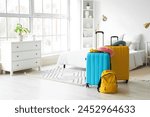 Suitcases with travel accessories in hotel room