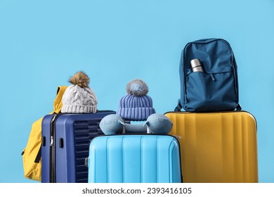 Suitcases with travelling accessories on blue background