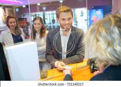 suited man buying ticket at booth