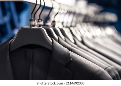 Suits in fashion store for men or in hanger in wardrobe. Jacket rack in apparel retail shop. New elegant luxury collection. Row of many stylish clothes. Expensive custom tailor made professional wear. - Powered by Shutterstock