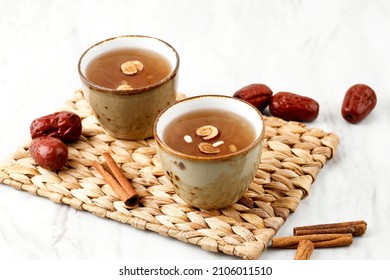Sujeonggwa, Korean Traditional Cinnamon Punch. Dark Reddish Brown in Color, it is Made from Cinnamon Stick, Gotgam, and Ginger and is Garnished with Pine Nuts and Red Dates Jujube. 