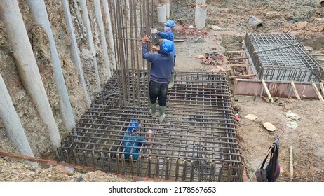 Sukabumi, Indonesia - July 15, 2022
: Indonesian Male Workers With Blue Project Masks And Helmets Are Installing Iron Pile Caps For Building Foundations