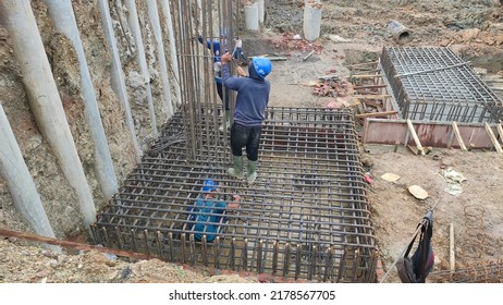 Sukabumi, Indonesia - July 15, 2022
: Indonesian Male Workers With Blue Project Masks And Helmets Are Installing Iron Pile Caps For Building Foundations