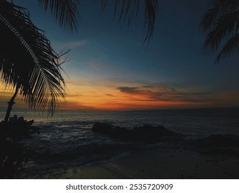 Sukabumi Indonesia, a serene beach scene at sunset, with palm fronds silhouetted against the warm, bright colors of the sunset. - Powered by Shutterstock