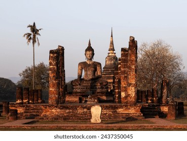 Sukhothai - Buddha statue and ancient pagoda. Old buddhist temple ruins. Sukhothai Historical Park. Thailand.