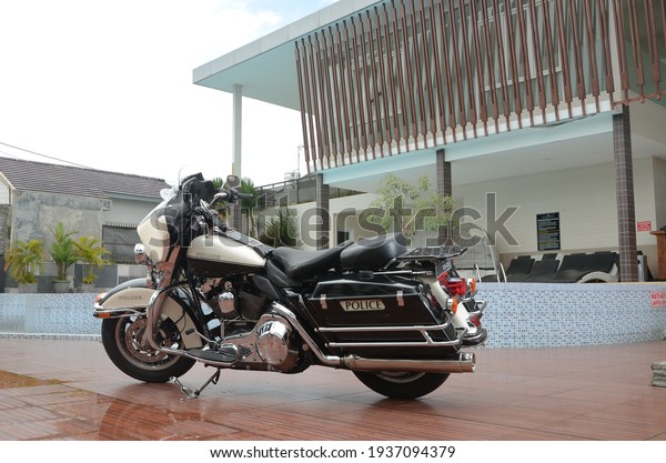 Sukoharjo, Central Java, Indonesia - 25\
February 2021: Black and White Harley Davidson Electra Police noise\
or blurring photos park near the lake during the\
day