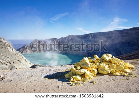 The sulfuric lake of Kawah Ijen vulcano in East Java with sulfur stone in foreground, Indonesia