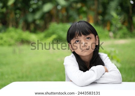 The sullen expression of an Asian girl with a flat face