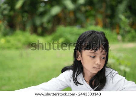 The sullen expression of an Asian girl with a flat face