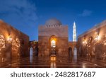 Sultan Qaboos Grand Mosque inner yard decorated walls and minaret shining at night, Muscat. Oman