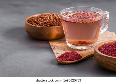 Sumac Water Or Tea And Dried Ground Red Sumac Spices In Wooden Spoon With Sumac Berries On Rustic Table. Healthy Food Concept