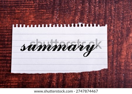 Summary text written in elegant script on a piece of torn lined paper against a wooden background. Concept for conclusion, report, and overview.