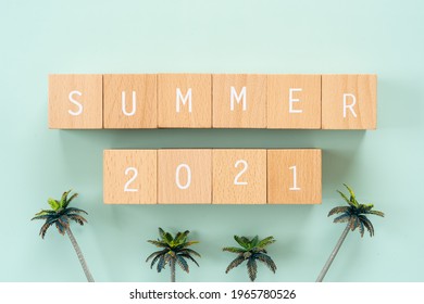 Summer 2021; Wooden blocks with "SUMMER 2021" text of concept and palm tree toys.