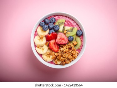 Summer Acai Smoothie Bowl With Strawberries, Banana, Blueberries, Kiwi Fruit And Granola On Pastel Pink Background. Breakfast Bowl With Fruit And Cereal, Close-up, Top View, Healthy Food