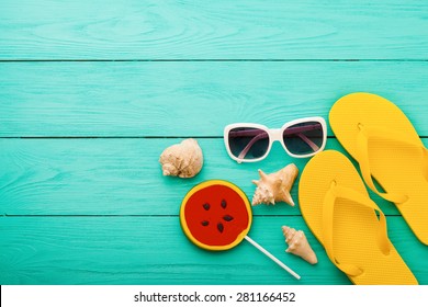 Summer accessories and shells with candy on blue wooden background. - Powered by Shutterstock