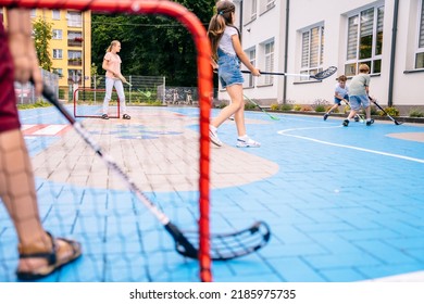 Summer activites for children concept. Group of children playing street hockey on a city holiday on the playground.