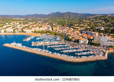 Summer aerial view of French coastal town of Sainte-Maxime on Mediterranean coast overlooking marina with moored pleasure yachts and residential houses on green hills - Shutterstock ID 2196807865