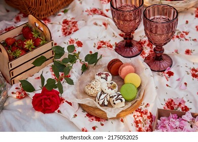 Summer Aesthetic Pink Picnic With Tablecloth Marshmallows, Macaroons, Strawberries, Glasses Of Wine Among Pink Roses In The Park. Romantic Dinner.