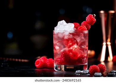 Summer alcoholic cocktail with mashed raspberries, gin, vodka, soda, and crushed ice, black background with bottles - Powered by Shutterstock