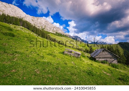 Summer alpine landscape with mountains and rickety wooden hut on the hill, Carpathians, Transylvania, Romania, Europe