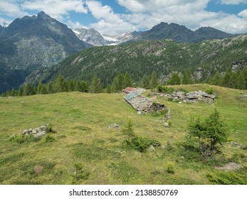 Summer Alpine landscape with ruined stone shelters and mountain peaks in Valmalenco, Italy - Shutterstock ID 2138850769