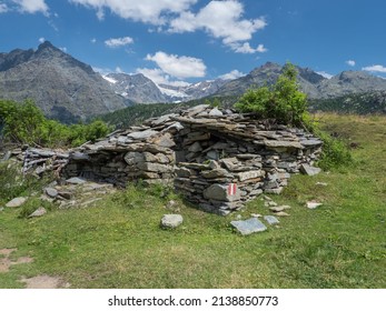 Summer Alpine landscape with ruined stone shelter and mountain peaks in Valmalenco, Italy - Shutterstock ID 2138850773