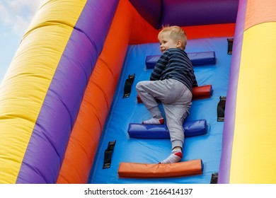 In the summer, in the amusement park, inflatable slide for kids climbs. - Shutterstock ID 2166414137