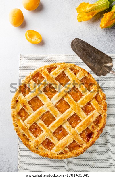 Summer
apricot or peach pie homemade on white background, top view.
Delicious fruit dessert. Fruit cake. Copy
space.