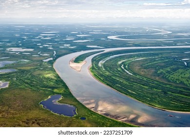 Summer Arctic landscape. Boundless tundra in the Far North. Aerial view of meanders (bends) of the river and many lakes. A cargo ship is sailing along the Anadyr river. Chukotka, Siberia, Russia. - Powered by Shutterstock