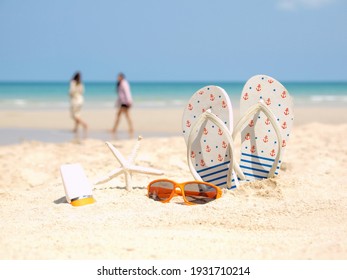 Summer assessories. Planing to travel with sunblock and sandal on the beatiful beach and blue sky background. Tropical fashion. Summer Fashion on holiday concept. 