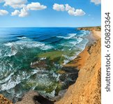 Summer Atlantic ocean coast landscape and Monte Clerigo beach (Aljezur, Algarve, Portugal).  Blue sky with some cumulus clouds.Three shots stitch high-resolution image.