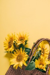 Summer Or Autumn Background. Wicker Bag With Bouquet Of Sunflower Flowers On Yellow Background. Flat Lay, Top View, Copy Space