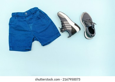 Summer babies blue clothes and accessories with jeans shorts,sneakers. Modern fashion kids outfit.Set of children's clothing for spring or summer. Flat lay, top view,overhead,mockup with copy space