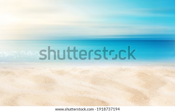 Summer background image of tropical\
beach with blurred horizon at sunset. Light sand of beach against\
backdrop of sparkling ocean water. Natural\
seascape.