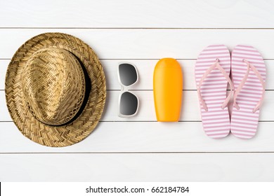 Summer Background With Straw Hat, Sunglasses, Sunscreen Bottle And Pink Flip Flops