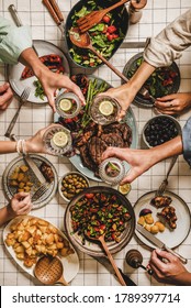 Summer Barbeque Party. Flat-lay Of Table With Grilled Meat, Vegetables, Salad, Roasted Potato And Peoples Hands Feasting Over Checkered Tablecloth, Top View. Family Gathering, Comfort Food Concept