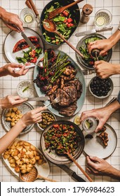 Summer Barbeque Party. Flat-lay Of Table With Grilled Meat, Vegetables, Salad, Roasted Potato And Peoples Hands Over Checkered White Tablecloth, Top View. Family Gathering, Comfort Food Concept