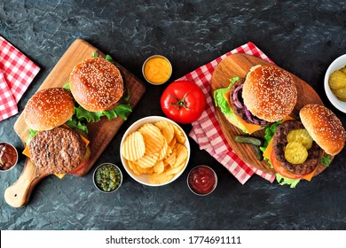 Summer BBQ Hamburger Table Scene. Overhead View On A Dark Slate Background.