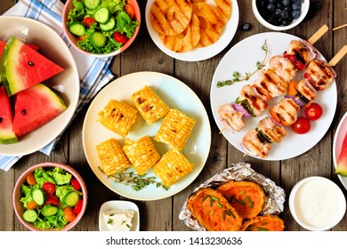 Summer BBQ Or Picnic Food Concept. Selection Of Fruits, Salad, Grilled Meat And Potatoes. Overhead Table Scene On A Rustic Wood Background.